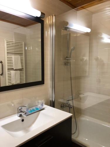 a bathroom with a sink and a shower and a tub at Hotel Solineu in La Molina