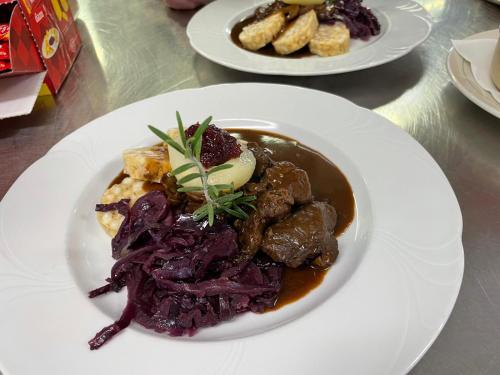 a plate of food with meat and vegetables on a table at Hospezi Santa Maria in Platta