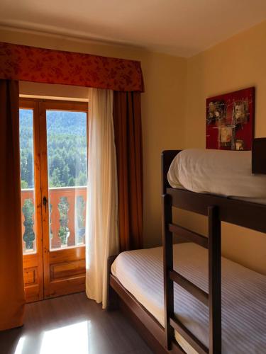 een slaapkamer met een stapelbed en een raam bij Hotel Solineu in La Molina