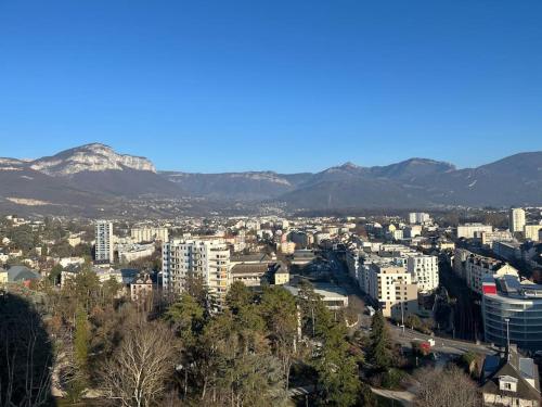 une ville avec des bâtiments et des montagnes en arrière-plan dans l'établissement T2 centre ville avec vue imprenable, à Chambéry