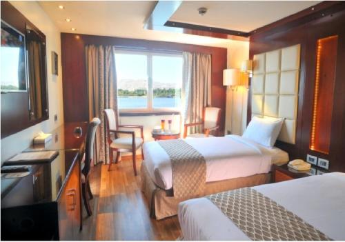 盧克索的住宿－live Nile in style Nile cruise in Luxor and Aswan，酒店客房设有两张床和窗户。