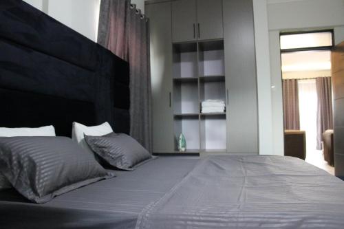 a bedroom with a large bed with a large headboard at MHP Apartments in Munyonyo