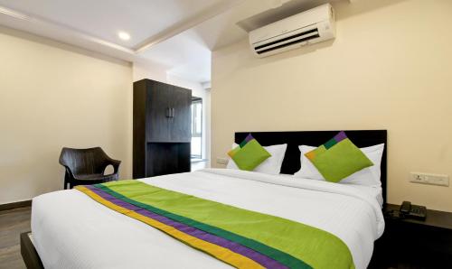 a bedroom with a large bed with a green blanket at Treebo Excella in Visakhapatnam