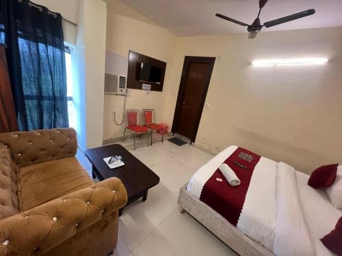 salon z łóżkiem i kanapą w obiekcie Hotel Kaushambi Grand w mieście Ghaziabad