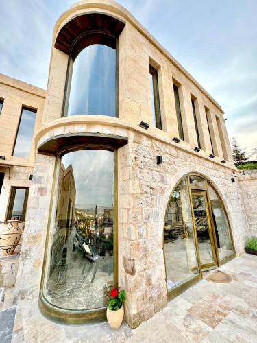 a stone building with large windows on it at Very Peri Cappadocia - The Lifestyle Luxury Design Hotel in Uchisar