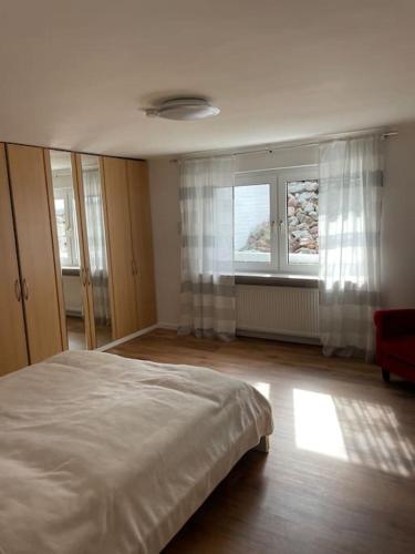 a bedroom with a large bed and two windows at Flughafennahe 100 qm Oase mit eigenem Fitnessraum in Holzwickede