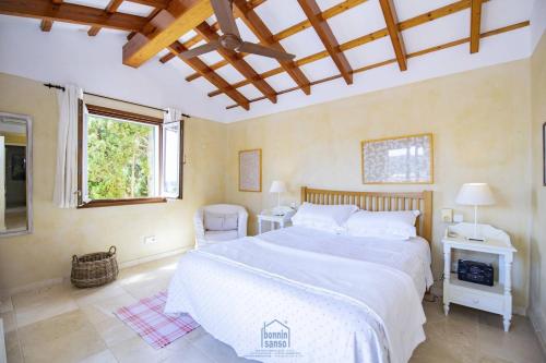 Un dormitorio con una gran cama blanca y una ventana en Lovely family villa sleeps 8, with stunning views en Mahón