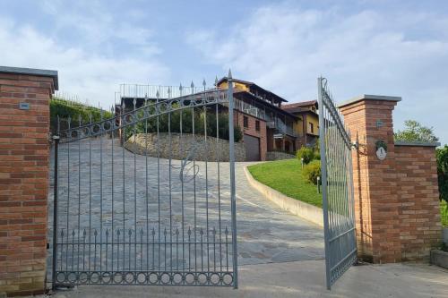 um portão para uma entrada com um edifício atrás em Casa Castella - Adults Only - Langhe em Diano dʼAlba