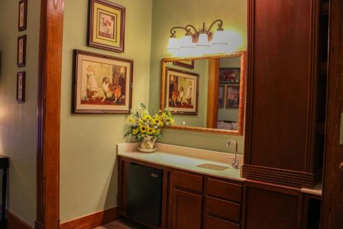 a bathroom with a sink and a mirror at Woodbine Inn and Restaurant in Madisonville