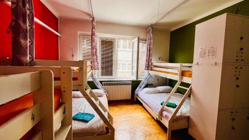 a small room with two bunk beds and a window at Hostel Balkan Han in Sarajevo