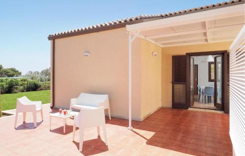 eine Terrasse mit weißen Stühlen und einem Tisch in der Unterkunft Beach Front Home In Marina Di Modica in Marina di Modica