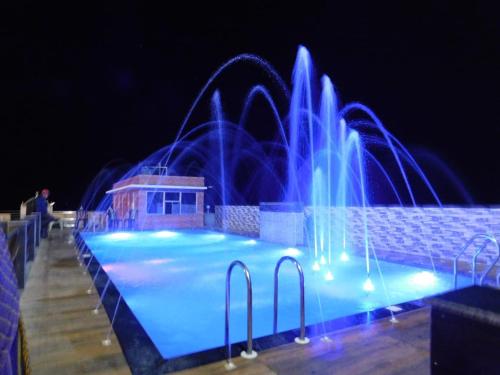 uma fonte numa piscina à noite em THE ROYAL BEACH HOTEL AND RESORT em Mandarmoni