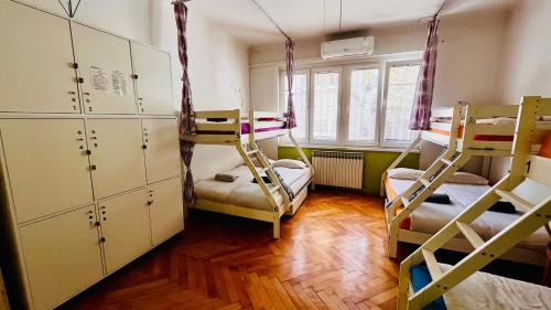 a room with two bunk beds and a room with cabinets at Hostel Balkan Han in Sarajevo