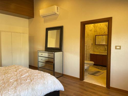 a bedroom with a bed and a bathroom with a toilet at Horizon Loft in Bilāl