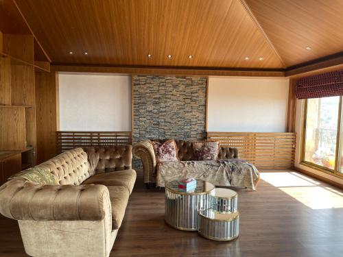 a living room with couches and a brick wall at Horizon Loft in Bilāl