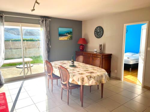 - une salle à manger avec une table et des chaises et une vue sur l'océan dans l'établissement Maison familiale à Vairé, à Vairé