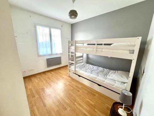 a bedroom with two bunk beds and a wooden floor at Maison familiale à Vairé in Vairé