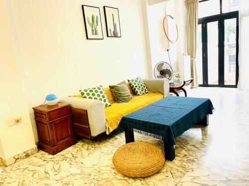 ein Wohnzimmer mit einem Sofa und einem Tisch in der Unterkunft Convenient Rare house in central city in Singapur