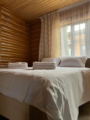 a large white bed in a room with a window at Soho Hutor in Bosteri