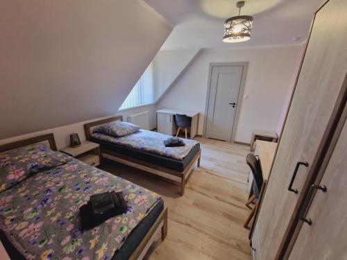 Zimmer mit 2 Betten und einem Tisch in der Unterkunft Wrzosowe Love in Raciąż