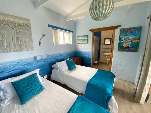 a bedroom with two beds with blue walls at Agulhasbestview in Agulhas