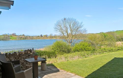 a patio with a table and a view of a river at Nice Home In Haderslev With Lake View in Haderslev