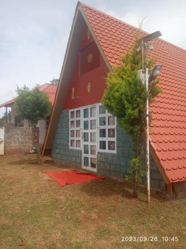 a red roofed house with a red roof at Green hut house in Yelagiri