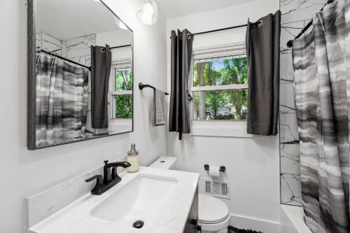 ein Badezimmer mit einem Waschbecken, einem Spiegel und einem WC in der Unterkunft Coastal Retreat Oasis- Perfect for large groups in Atlanta
