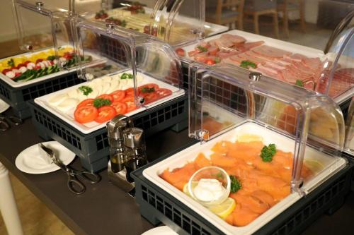 a buffet with many different types of food in plastic trays at Hotel Märkischer Hof in Luckenwalde
