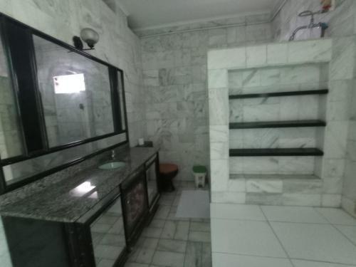 a bathroom with a sink and a large mirror at Canto do Casarão in Santos