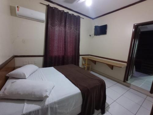 a bedroom with a large bed and a window at Canto do Casarão in Santos