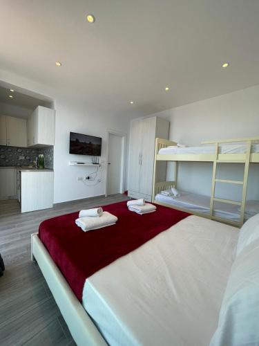 a bedroom with a large bed with two bunk beds at Panorama Sea View Apartments in Vlorë