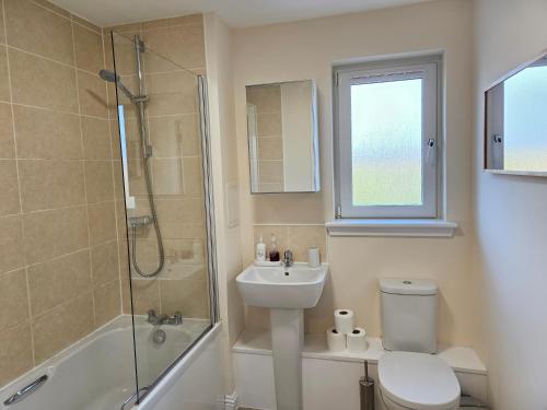 a bathroom with a toilet and a sink and a shower at Sensational Stay Apartments @ Torwood in Edinburgh