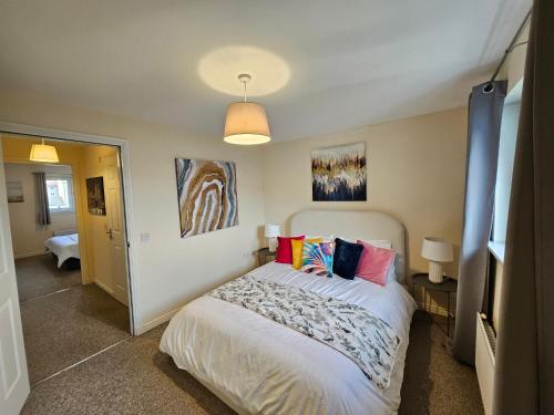 a bedroom with a bed with colorful pillows on it at Sensational Stay Apartments @ Torwood in Edinburgh