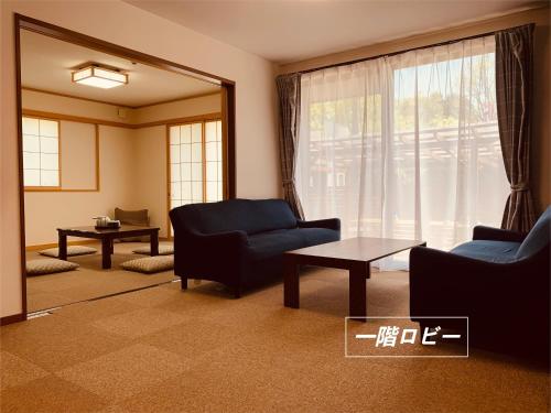 a living room with a blue couch and a mirror at 道龍house in Azagawa