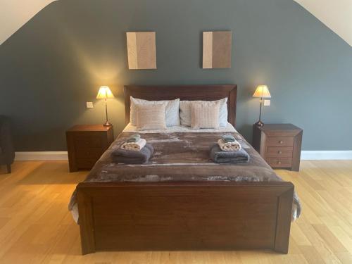 1 dormitorio con 1 cama grande de madera y 2 lámparas en Reenconnell Dingle, en Dingle