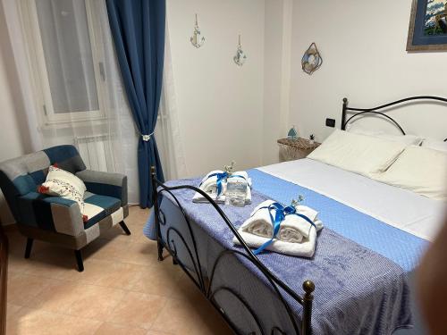 ein Schlafzimmer mit einem Bett und einem Stuhl mit Handtüchern darauf in der Unterkunft Casa vacanze Bella Vista in Campomarino