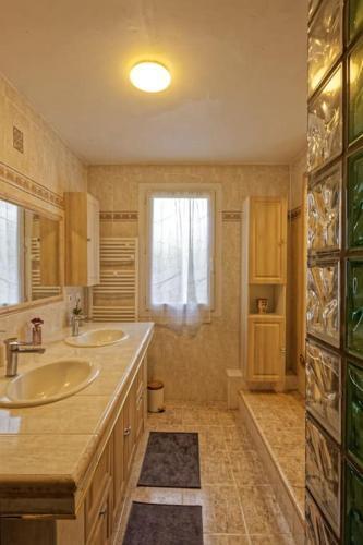 une salle de bain avec deux lavabos et une fenêtre dans l'établissement Magnifique T4 Uzès au calme, à Uzès