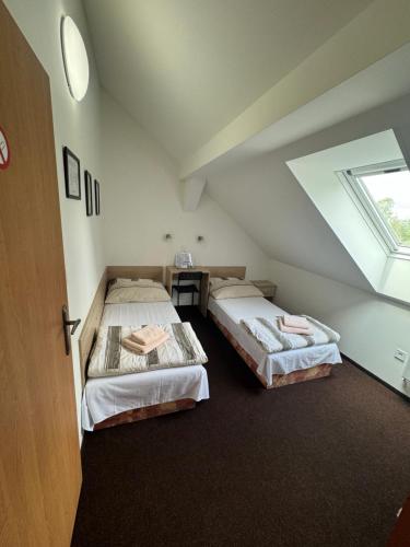 two beds in a room with a window at Hotel Formule in Děčín