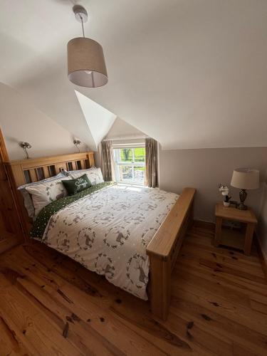 um quarto com uma cama grande e uma janela em The Old Barn em Fivemiletown
