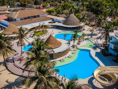 an aerial view of a resort pool with palm trees at Kombo Beach Resort in Serekunda