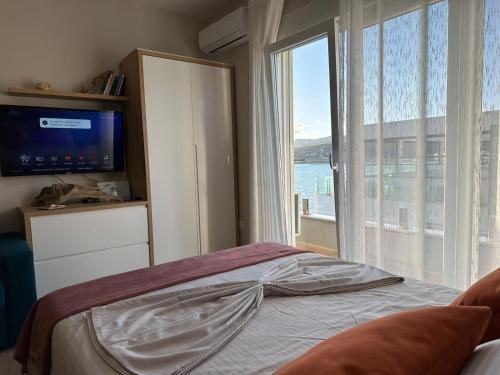 a bedroom with a bed and a large window at Sea La Vie in Shëngjin