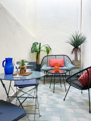 un patio avec des chaises, des tables et des plantes dans l'établissement Appartements art déco centre-ville, spacieux et lumineux, à Perpignan