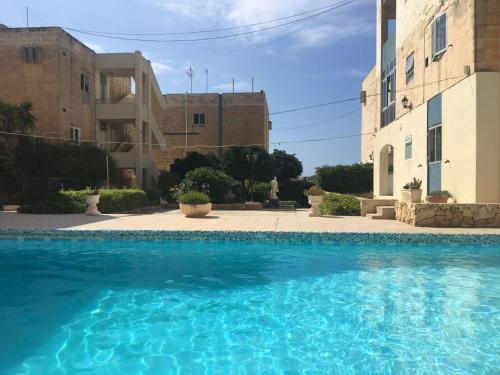 a large swimming pool in front of a building at Beautiful flat with Swimming-pool & Seaview in St. Paul's Bay
