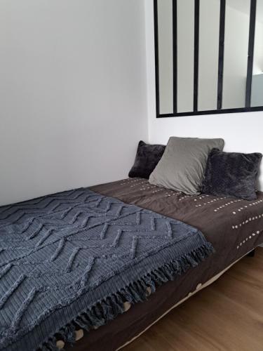 un letto in una camera bianca con una coperta nera di Studio Pleuven a Pleuven