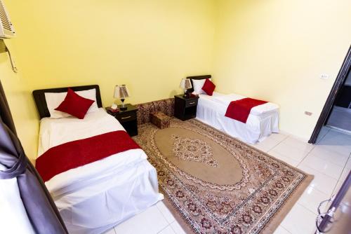 a room with two beds and a rug at العييري للشقق 014 يومي وشهري بالمدينة in Al Madinah