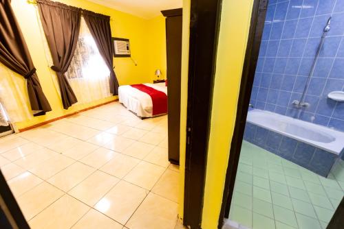 a room with a bathroom with a bed and a tub at العييري للشقق 014 يومي وشهري بالمدينة in Al Madinah