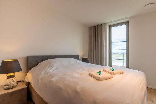 a bedroom with a bed with towels on it at New apartment on a marvelous location in Ostend