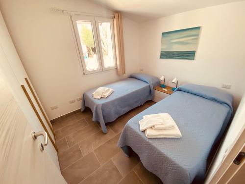 a bedroom with two beds and a window at Casa Mariposa Porto Rotondo in Rudalza