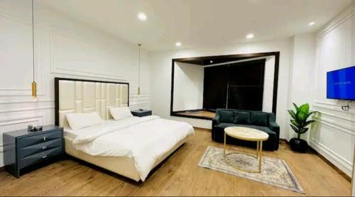 1 dormitorio con 1 cama blanca grande y 1 silla en Premium 1BR DHA Phase 5, en Lahore